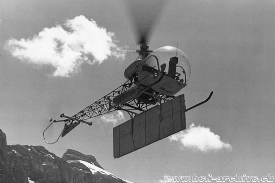 Linthtal, summer 1955 - Heliswiss' Bell 47G HB-XAK transporting material for the construction of a shack (HAB)