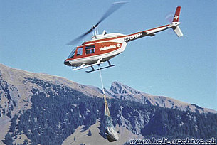 Swiss alps, 1970s - The Bell 206A/B Jet Ranger II HB-XCT in service with Heliswiss employed for the transportation of gravel (E. Devaud)