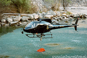 Lodrino/TI, March 2003 - The AS 350B3 Ecureuil HB-ZEJ descends over the Ticino river to refill its bumby bucket - (M. Bazzani)