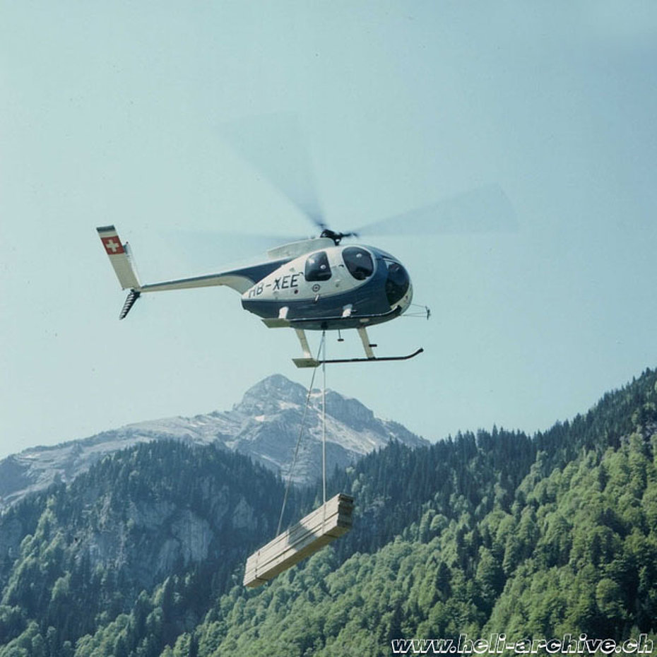 Alpi svizzere 1975 - Lo Hughes 500C HB-XEE impegnato nel trasporto di materiale (archivio Fuchs Helikopter)