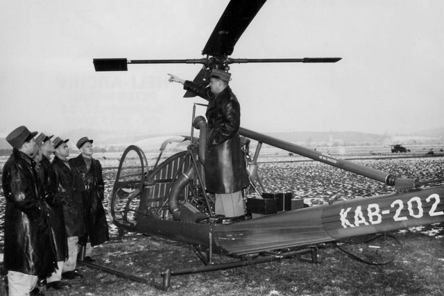 Emmen/LU, dicembre 1952 - Hansueli Weber in piedi sulla fusoliera dell'Hiller UH-12B KAB-202 fornisce spiegazioni tecniche ai primi candidati piloti d'elicottero dell'esercito Svizzera (HAB)